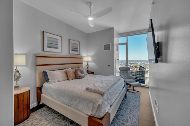 bedroom featuring hardwood / wood-style flooring, ceiling fan, and floor to ceiling windows