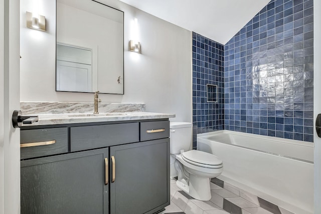 full bathroom featuring tile patterned floors, vanity, tiled shower / bath combo, vaulted ceiling, and toilet