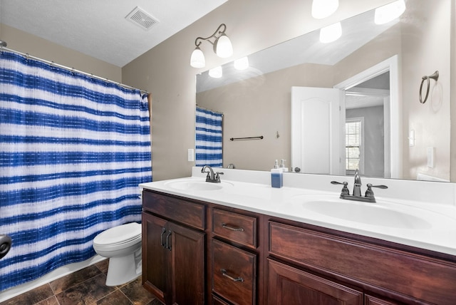 bathroom featuring toilet, vanity, a textured ceiling, and curtained shower