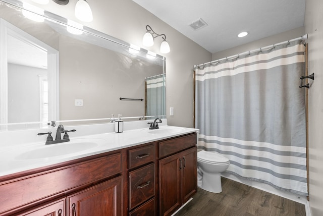 bathroom featuring walk in shower, hardwood / wood-style floors, vanity, and toilet