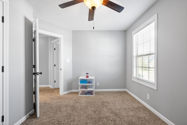 interior space with carpet floors and ceiling fan