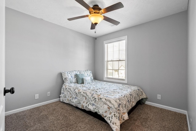 carpeted bedroom featuring ceiling fan and a textured ceiling