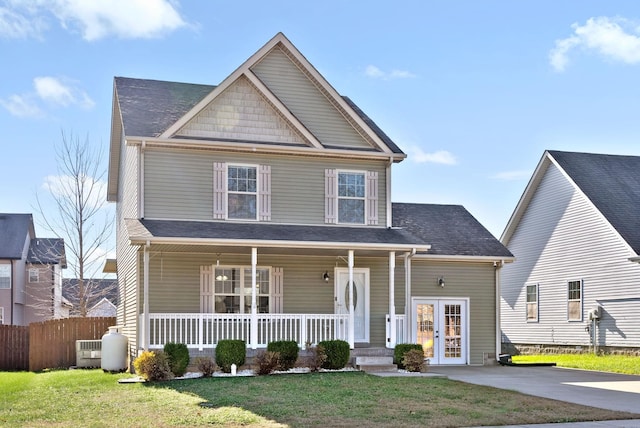 view of front of house featuring french doors, covered porch, and a front lawn