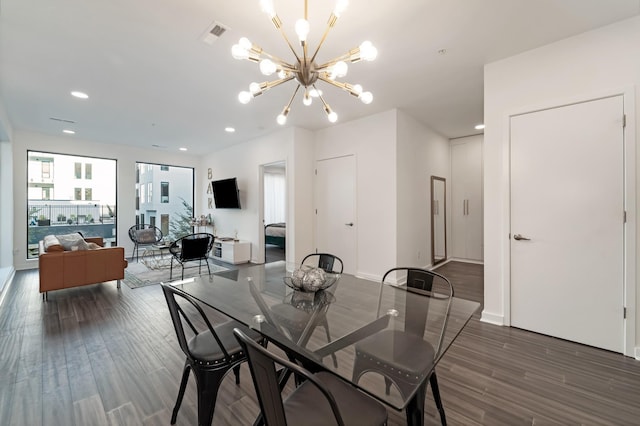 dining room with dark wood-type flooring and a notable chandelier