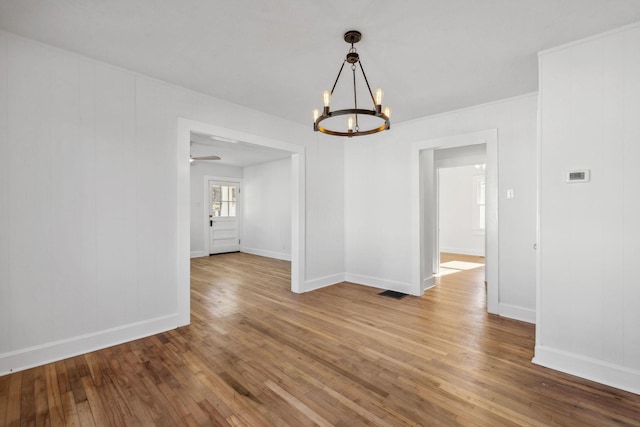 unfurnished room with hardwood / wood-style floors and a chandelier