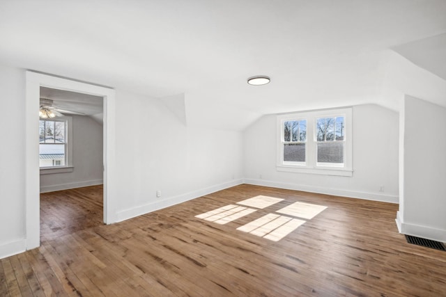 additional living space with hardwood / wood-style floors, lofted ceiling, and a healthy amount of sunlight