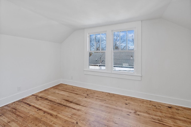 additional living space with hardwood / wood-style floors and lofted ceiling