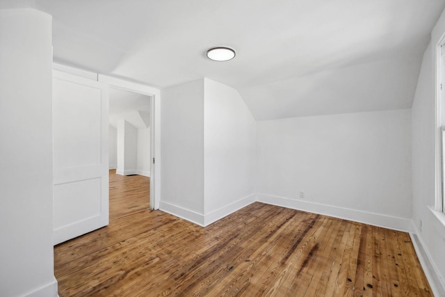 additional living space featuring hardwood / wood-style floors and lofted ceiling