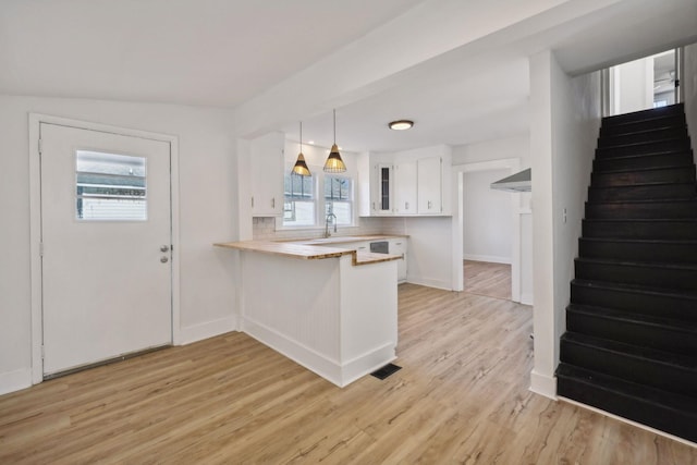 kitchen featuring pendant lighting, white cabinetry, kitchen peninsula, and a wealth of natural light