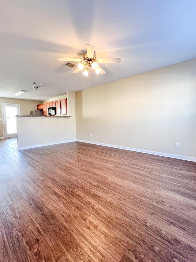 unfurnished living room featuring ceiling fan and hardwood / wood-style flooring