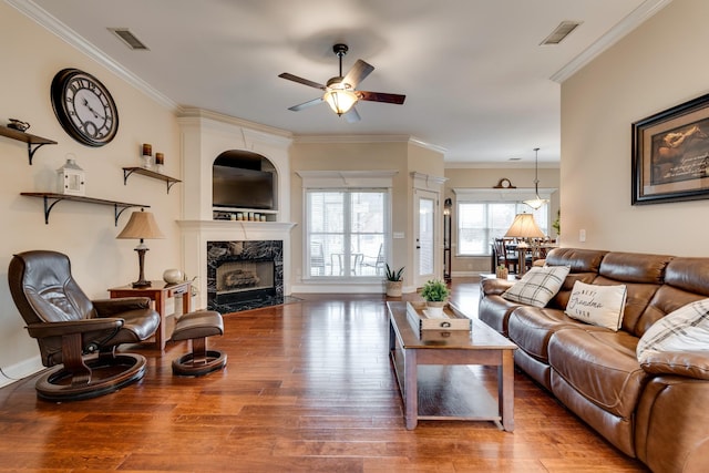 living room with a fireplace, hardwood / wood-style flooring, ceiling fan, and ornamental molding