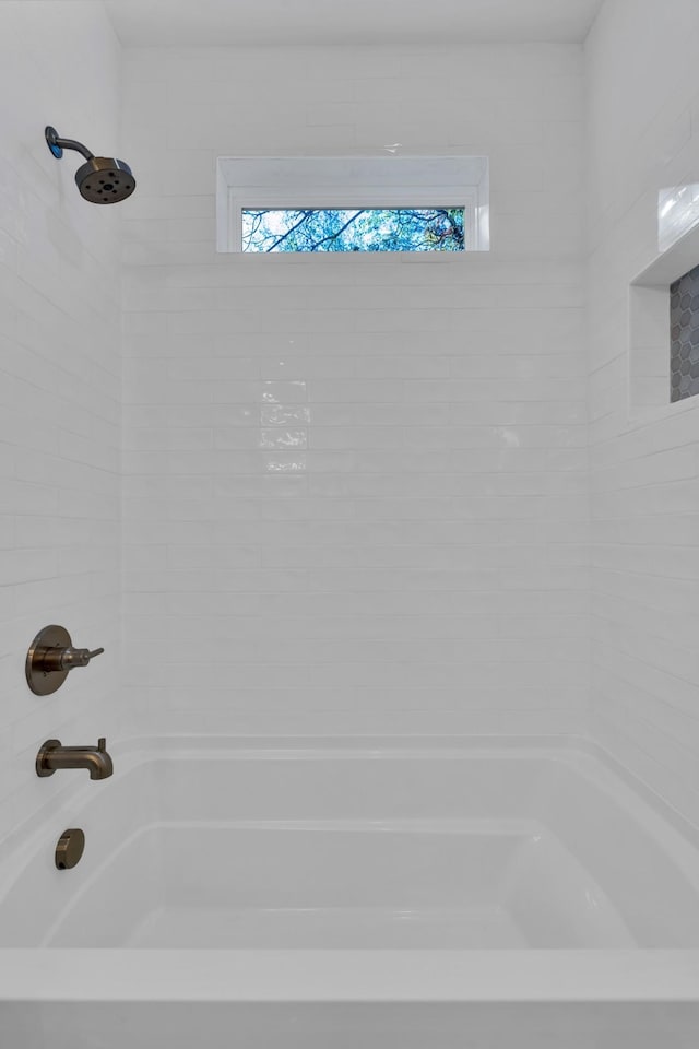 bathroom featuring tiled shower / bath combo and a wealth of natural light