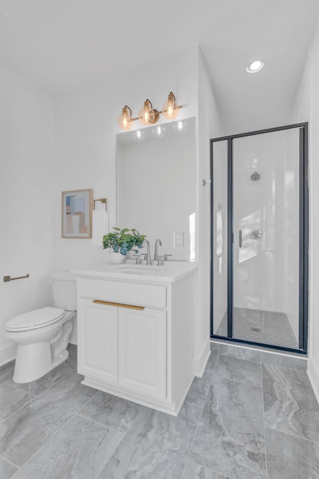 bathroom with a shower with door, vanity, and toilet