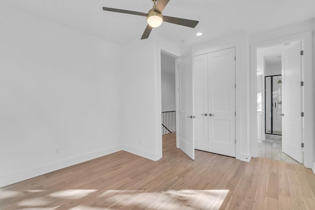 unfurnished bedroom with a closet, light hardwood / wood-style floors, and ceiling fan