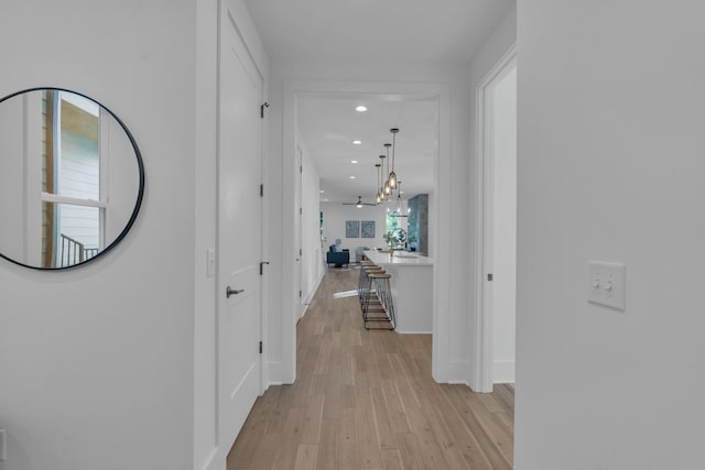 hall featuring a chandelier and light wood-type flooring