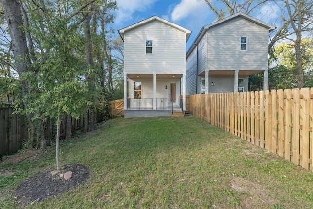 back of house featuring a porch and a yard