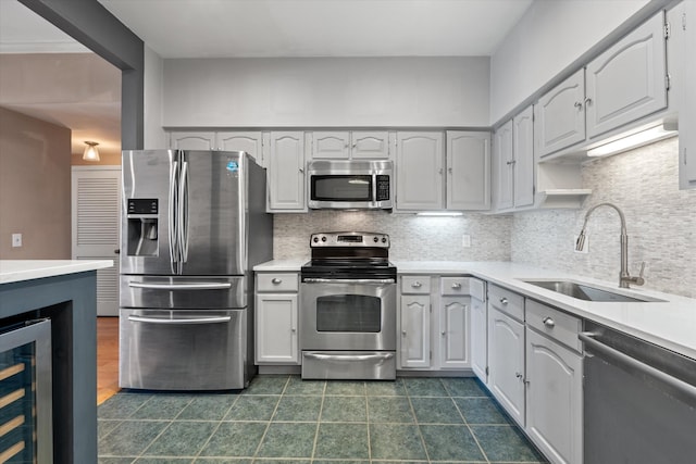 kitchen featuring backsplash, stainless steel appliances, beverage cooler, sink, and white cabinetry