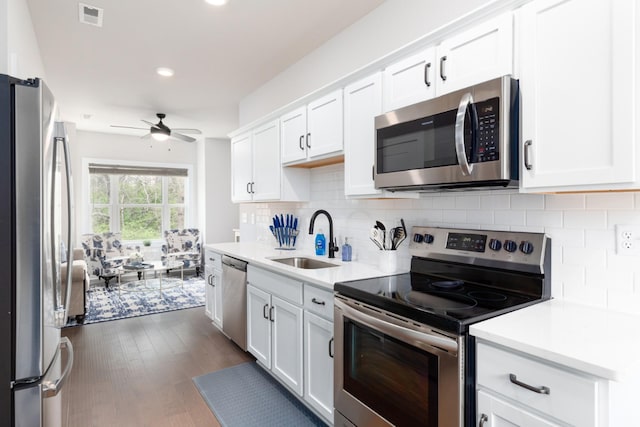 kitchen with white cabinetry, sink, ceiling fan, stainless steel appliances, and dark hardwood / wood-style floors