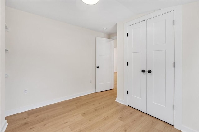 unfurnished bedroom with light hardwood / wood-style floors and a closet