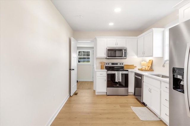 kitchen featuring sink, white cabinetry, light hardwood / wood-style flooring, and stainless steel appliances