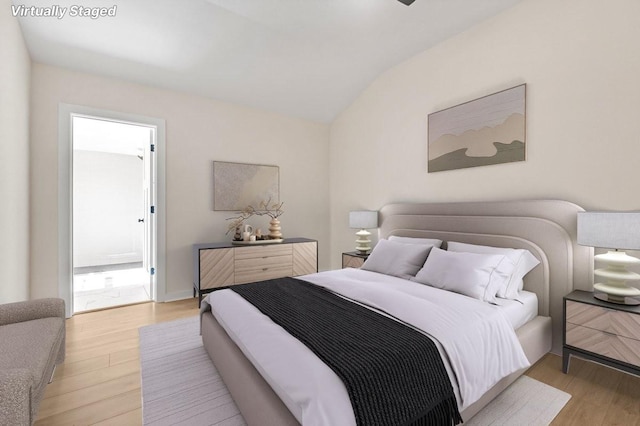 bedroom with vaulted ceiling and light hardwood / wood-style flooring