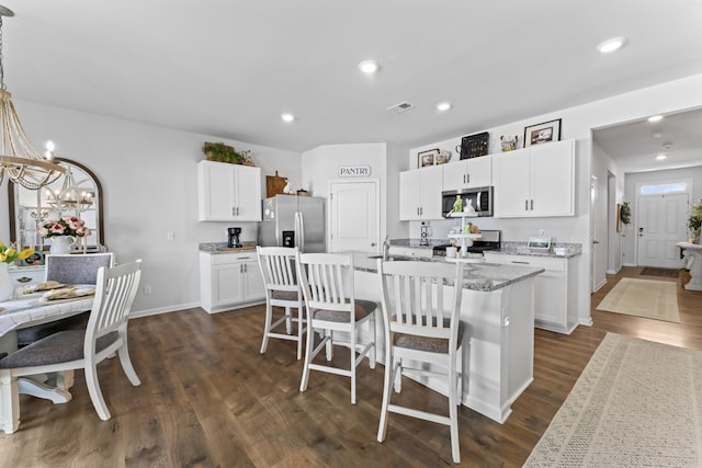 kitchen with a center island with sink, dark hardwood / wood-style floors, white cabinets, and appliances with stainless steel finishes