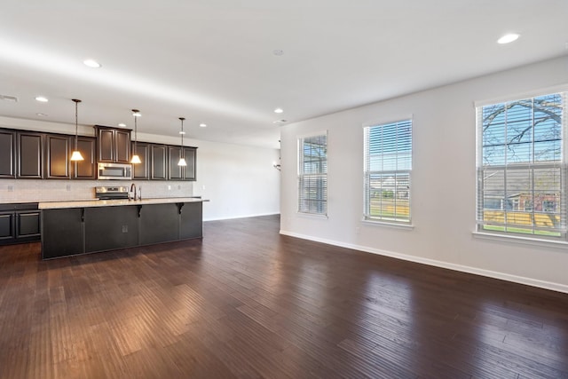 kitchen with pendant lighting, plenty of natural light, a breakfast bar, and appliances with stainless steel finishes