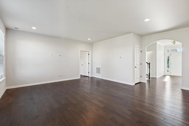 spare room featuring dark hardwood / wood-style flooring and plenty of natural light