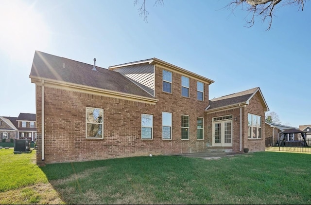 rear view of property featuring french doors, a yard, and central air condition unit