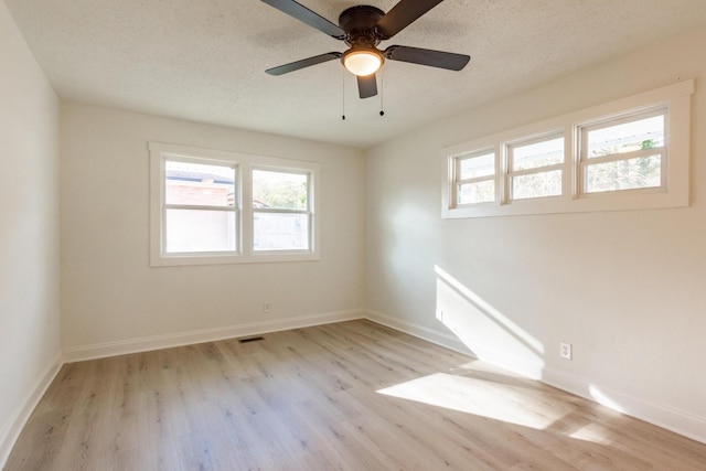 spare room with ceiling fan, a textured ceiling, and light hardwood / wood-style flooring