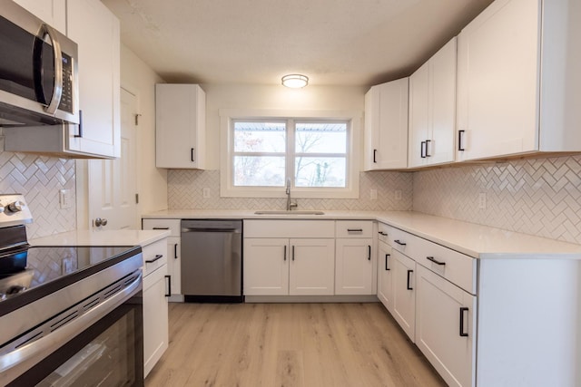 kitchen featuring white cabinets, appliances with stainless steel finishes, and sink