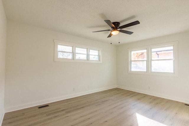 unfurnished room featuring a textured ceiling, light hardwood / wood-style flooring, and ceiling fan