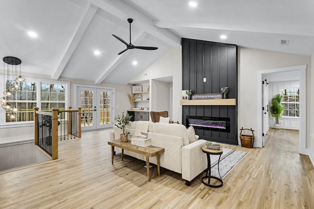 living room featuring ceiling fan, french doors, lofted ceiling with beams, light hardwood / wood-style floors, and a fireplace