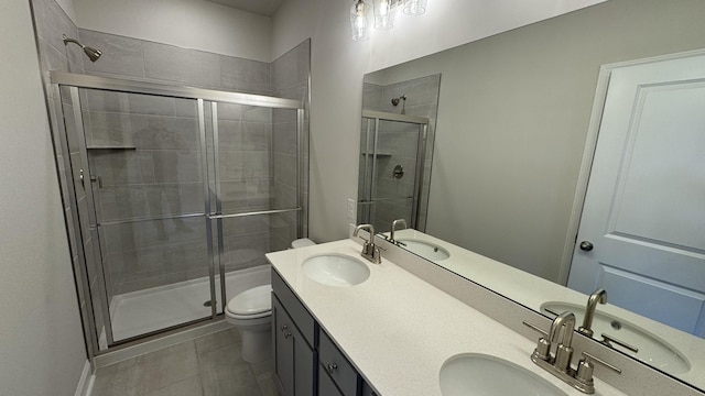 bathroom featuring toilet, vanity, tile patterned flooring, and walk in shower