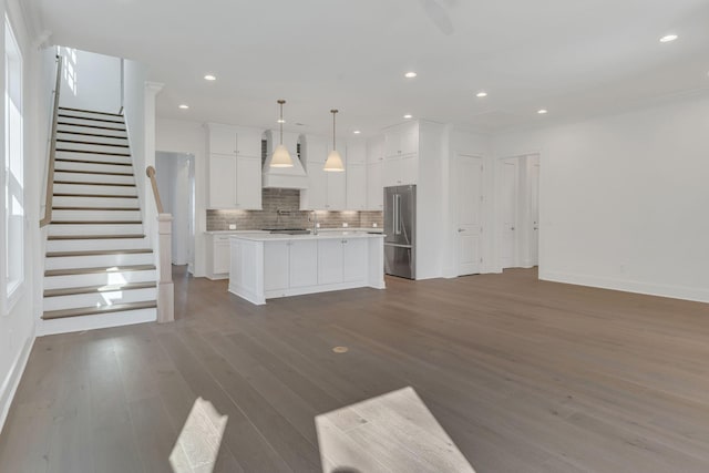 kitchen with backsplash, high quality fridge, open floor plan, and light countertops