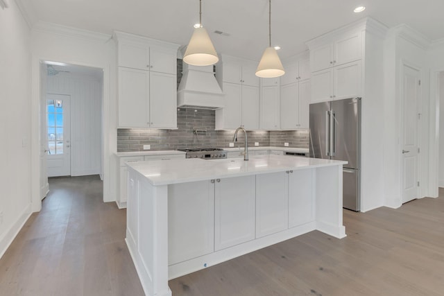 kitchen featuring light countertops, wood finished floors, freestanding refrigerator, and custom range hood