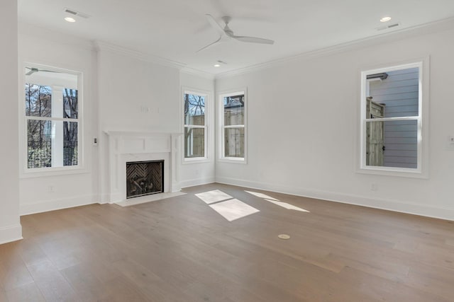 unfurnished living room featuring plenty of natural light, visible vents, crown molding, and wood finished floors