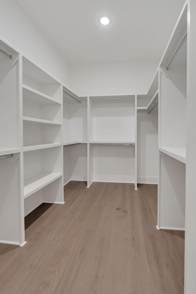 walk in closet with wood finished floors