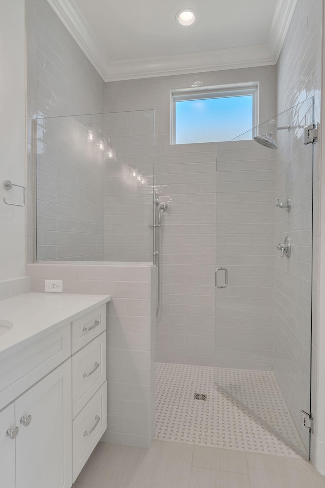 full bath featuring tile walls, a shower stall, vanity, and crown molding