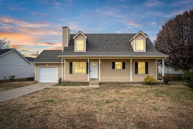 new england style home featuring covered porch, a garage, and a lawn