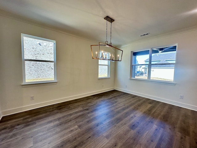 empty room with dark wood-style flooring, visible vents, baseboards, ornamental molding, and an inviting chandelier