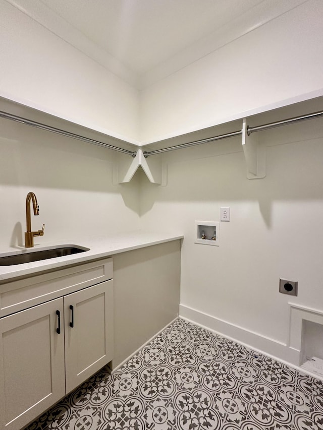 clothes washing area with cabinet space, hookup for a washing machine, tile patterned flooring, electric dryer hookup, and a sink