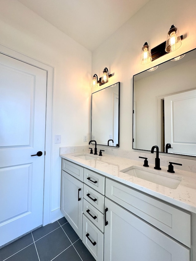 full bath with double vanity, a sink, and tile patterned floors