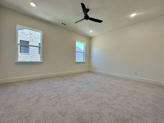 spare room with baseboards, recessed lighting, visible vents, and light colored carpet