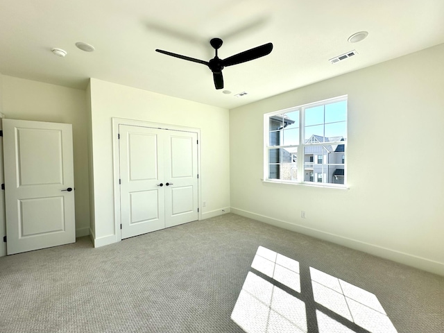 unfurnished bedroom with carpet floors, baseboards, visible vents, and a closet