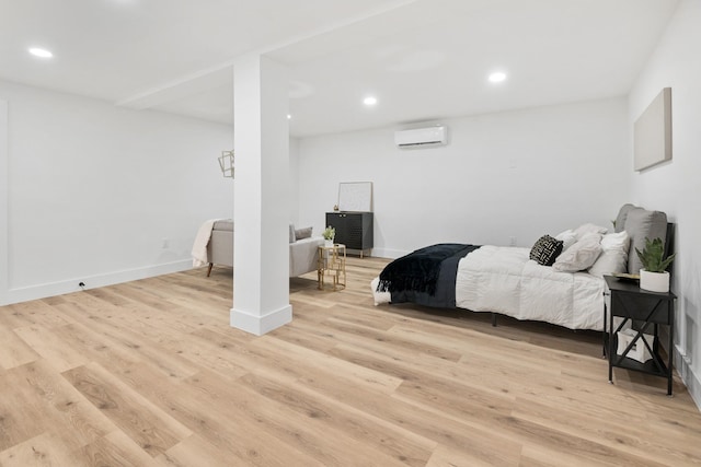 bedroom with light wood-type flooring and an AC wall unit