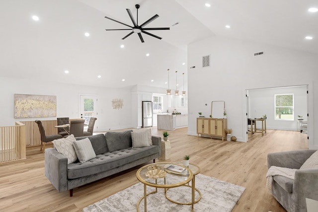 living room featuring high vaulted ceiling, light hardwood / wood-style flooring, and ceiling fan