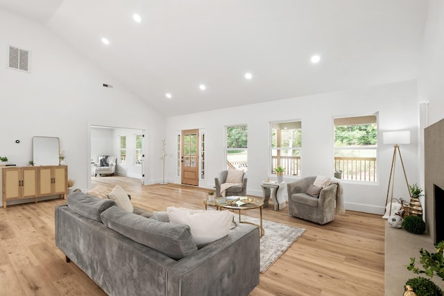 living room featuring light hardwood / wood-style flooring and high vaulted ceiling