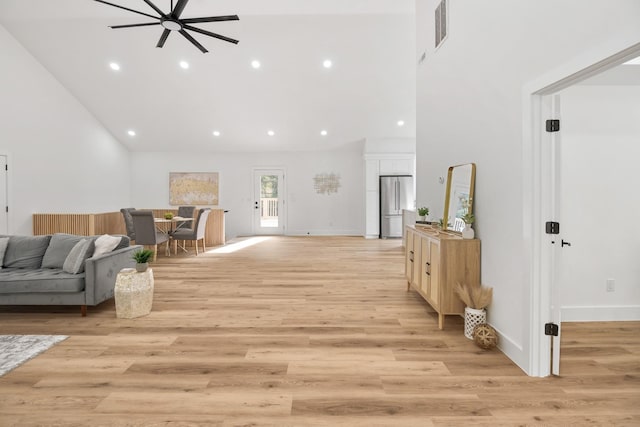 interior space with light hardwood / wood-style flooring and a towering ceiling