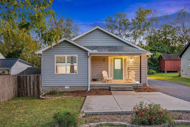 bungalow-style house with a lawn and covered porch